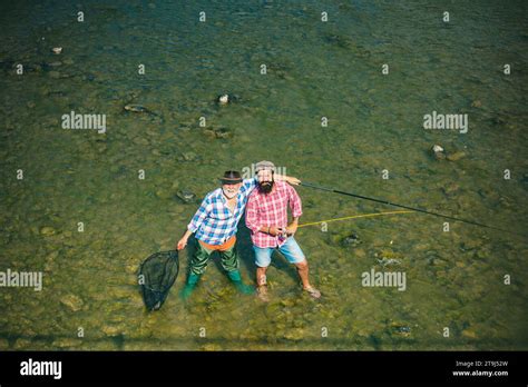 Two Men Friends Fisherman Fishing On River Old Father And Son With Rod