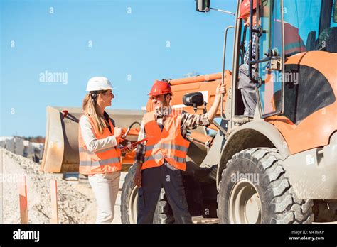 Civil Engineer And Worker Discussion On Road Construction Site Stock