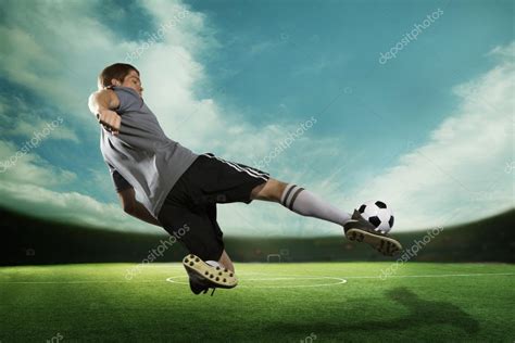 Soccer player kicking the soccer ball in mid air — Stock Photo ...