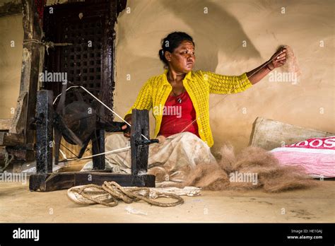A local woman is spinning sheep wool with a traditional spinning wheel ...
