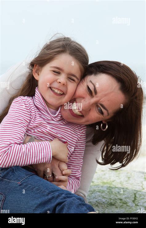 Mother And Daughter Cuddling On The Beach Stock Photo Alamy