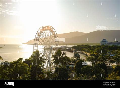 Golden Hour Over The Ferris Wheel Treetops Lagoon And Hilly Backdrop