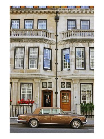 A Brown Car Parked In Front Of A Tall Building