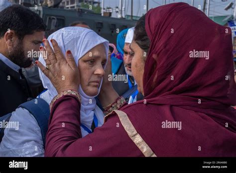 A Kashmiri Muslim Pilgrim In White Speaks With A Relative As She