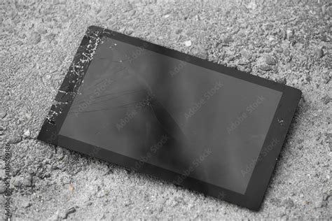 Broken tablet with cracked screen on the pavement Stock Photo | Adobe Stock