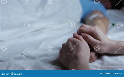 Рука человека с капельницей в женщине на больничной койке спать держит ...