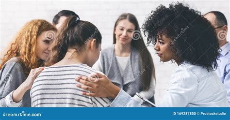 Support Group Patients Comforting Woman At Therapy Session Stock Photo