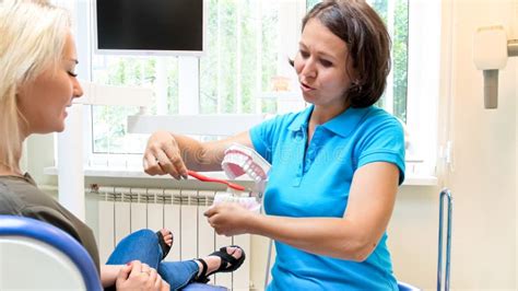 Retrato Del Dentista De Sexo Femenino Que Habla Con Su Paciente Sobre