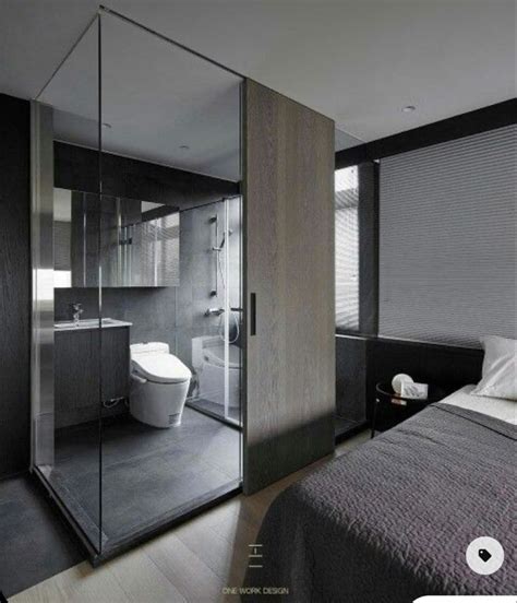 A Bedroom With A Bed Toilet And Shower In The Corner Next To A Glass