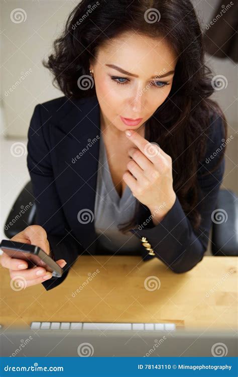 Professional Business Woman Sitting At Desk With Mobile Phone Stock