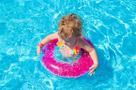 Un Ni O Nada En Una Piscina Con Un C Rculo Foco De Selecci N Foto Premium