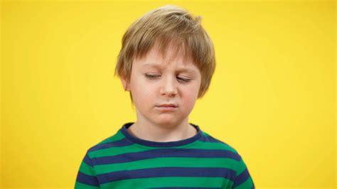 Close Up Portrait Of Tired Little Boy Yawning At Yellow Background