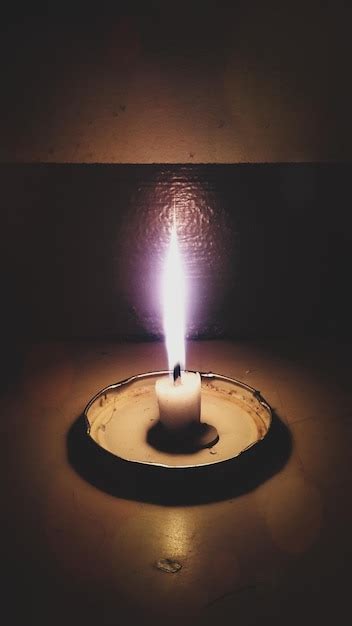 Premium Photo Illuminated Candle Against Wall In Darkroom