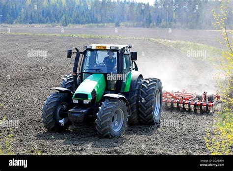 Farmer Cultivating Field With Green Deutz Fahr Agrotron 135 Tractor And