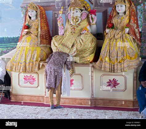 A Hindu Worshiper Praying In Front Of A Statue Of The God Ganesh At The