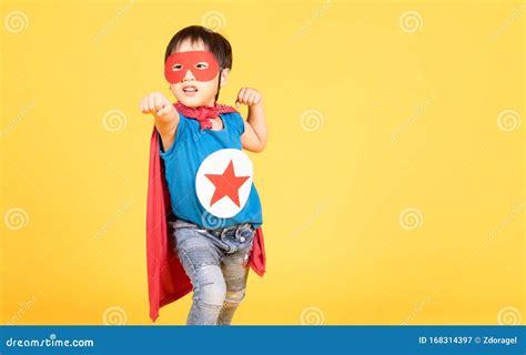 Cute Little Asian Child Boy Playing Superhero On The Yellow Wall