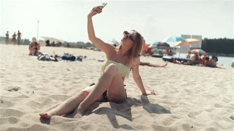 Mujer Bonita En El Bikini Que Se Sienta En La Playa Y Que Toma Un