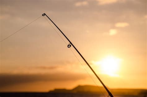 Silueta De Ca A De Pescar De Pescador Al Atardecer Naranja Foto Premium