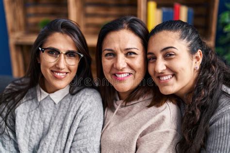 Three Woman Hugging Each Other Sitting On Sofa At Home Stock Photo