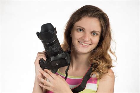 La Jeune Belle Fille Sourit Et Tient Un Appareil Photo Sur Un Backgr