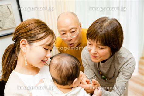 0歳の赤ちゃんを抱っこする日本人の母親と赤ちゃんをあやす祖父母 （人物）の写真素材 [216089362] イメージマート