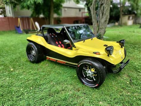 A Yellow And Black Dune Buggy Parked In The Grass