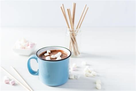 Premium Photo Hot Chocolate With Marshmallows In A Blue Enamel Mug On White Table