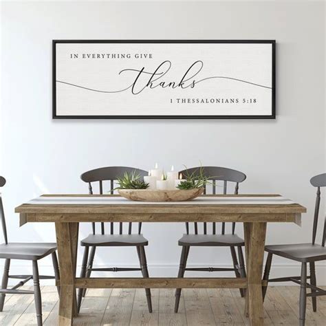 Two Framed Pictures On The Wall Above A Dining Room Table With Chairs