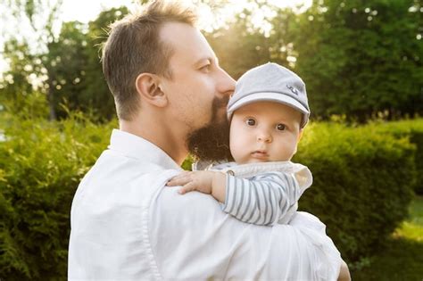 Padre Sosteniendo A Su Hijo En Sus Brazos Sobre Un Fondo De Vegetaci N