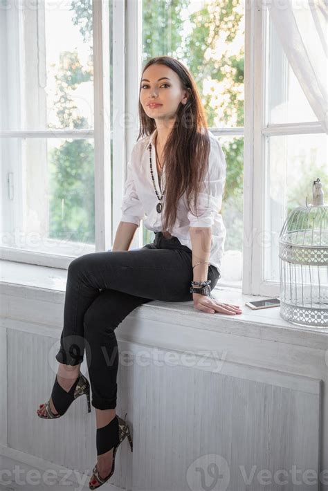 Beautiful Brunette Sitting By The Window Stock Photo At Vecteezy