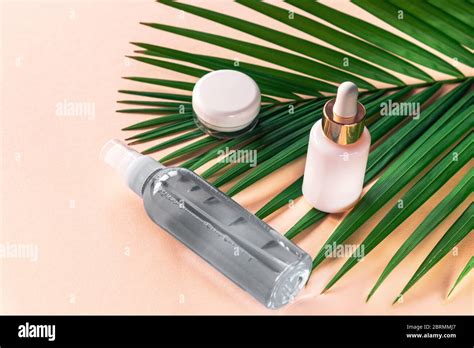 Facial And Body Care Cosmetics Bottles On Yellow Background Serum