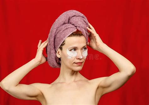 Slender Half Naked Woman With A Towel On Her Head Hands Near The Head Cosmetic Patches Under