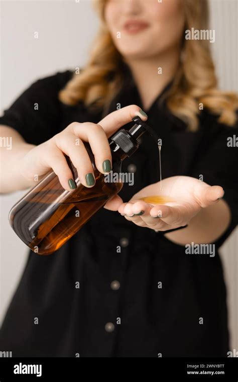 Woman Pouring Oil Into Her Hand Preparing To Massage Her Shoulder