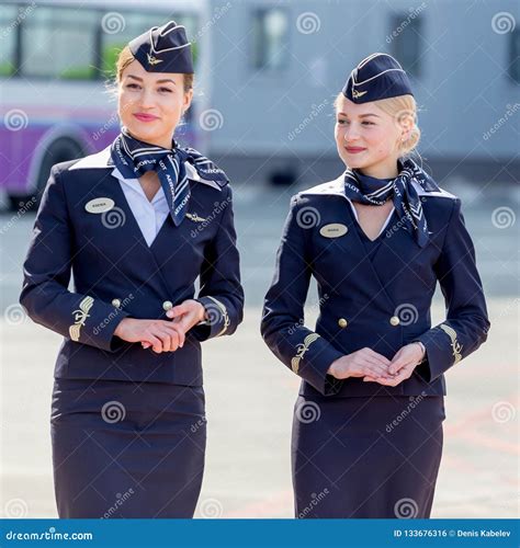 Beautiful Stewardesses Dressed In Official Dark Blue Uniform Of