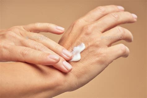 Female Hands With Nude Manicure On Nails Applying Hand Cream Stock Photo By KostiantynVoitenko