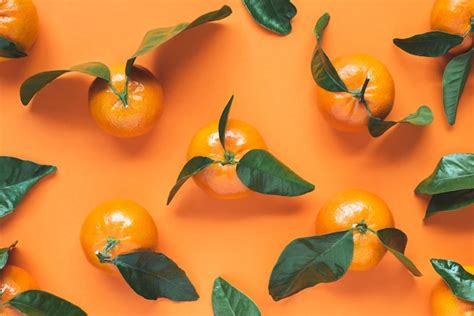 Premium Photo Fresh Mandarins With Leaves On Orange Background