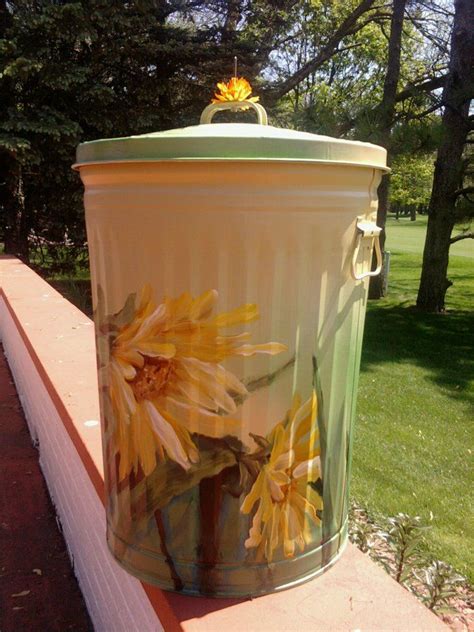 A Trash Can With Yellow Flowers Painted On It