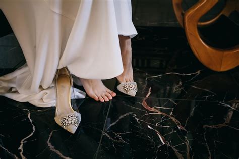 La novia se pone los zapatos de boda por la mañana antes de la