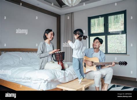 Mom And Dad And Daughter Sing At Home Stock Photo Alamy