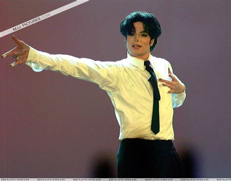 A Man In White Shirt And Black Tie Pointing At Something With His Right