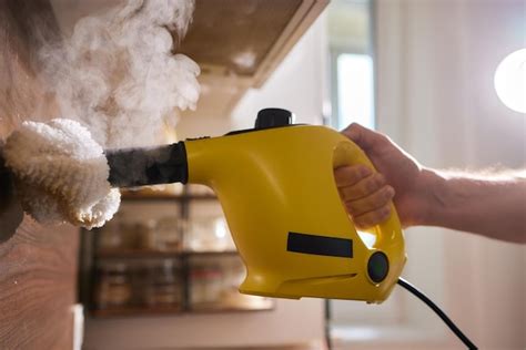 Premium Photo | Cleaning kitchen hob with a steam cleaner