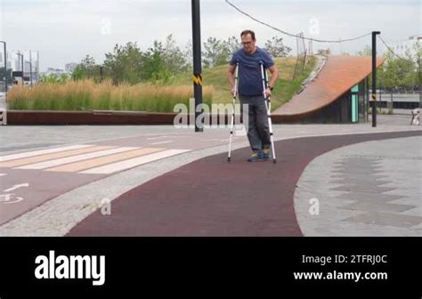 Plus Size Man Walking On Crutches In Riverside Park Stock Video Footage
