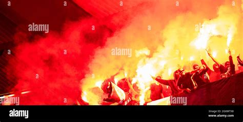 Football Hooligans With Mask Holding Torches In Fire While Supporting