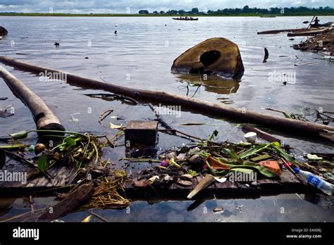 Pollution, logs and rubbish line the shore of the Amazon River near ...