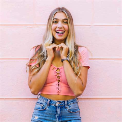 A Blonde Woman Is Smiling And Making A Face With Her Hands Premium AI