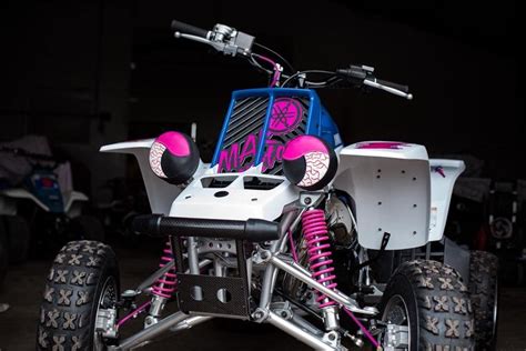 A Pink And White Four Wheeler Parked In A Garage