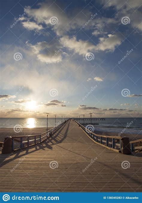 Sunset And Vacationers On The Bridge Of Palanga On The Baltic Sea In