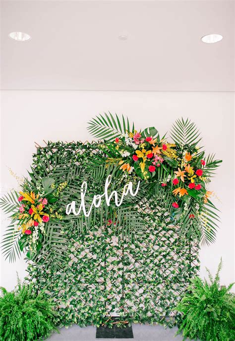 The Wedding Sign Is Surrounded By Greenery And Tropical Flowers Which Are Arranged On Top Of