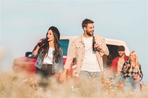 Cerveja Bebendo Dos Pares Felizes Novos No Campo De Flor Quando Seu