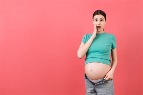 Premium Photo Pregnant Woman In Unzipped Jeans Showing Her Naked Belly At Colorful Background